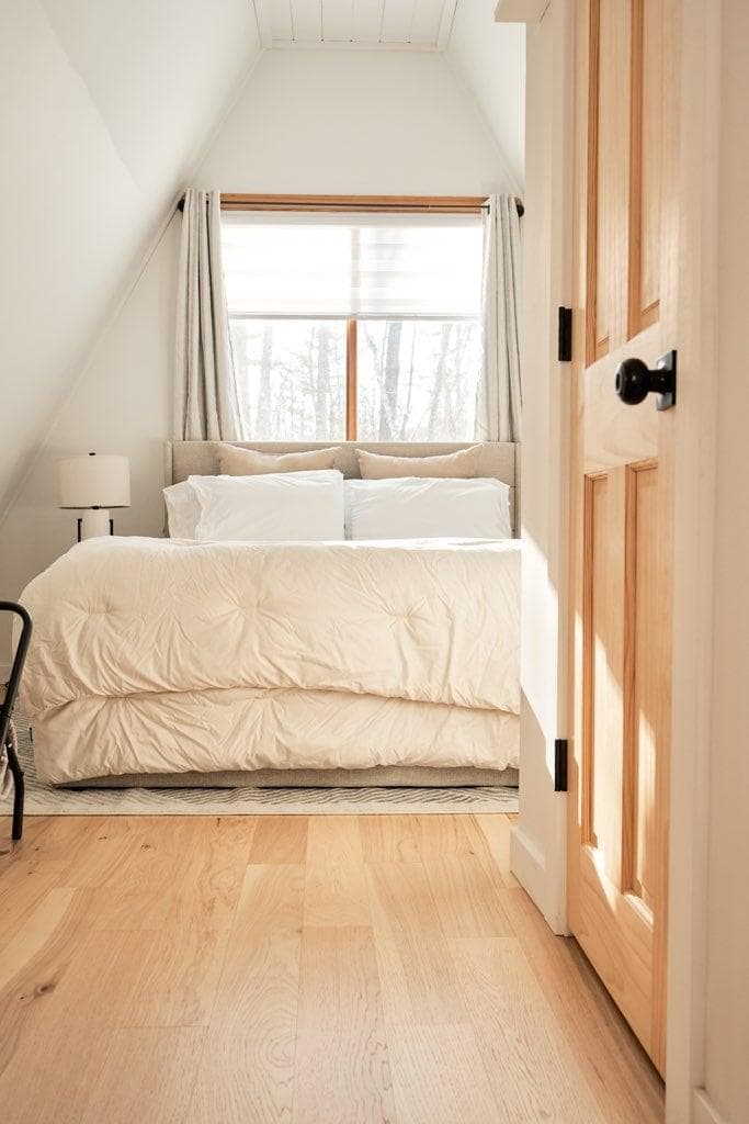 Enter into the upstairs oasis featuring lush queen bed, amazing natural light, extra blankets, closet storage, and half bath.